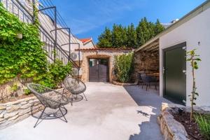 a patio with two chairs and a building at Villa Harmony in Supetar