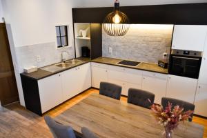 uma cozinha com uma mesa de madeira e uma sala de jantar em EN PASSANT appartement em Diksmuide