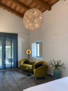 a living room with two chairs and a chandelier at Collina d’Oro in Belforte del Chienti
