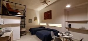 a bedroom with two beds and a table and a kitchen at Las Heliconias in Oaxaca City