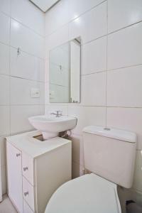 a white bathroom with a toilet and a sink at Apto com Wi-Fi na região central, na Liberdade - SP in São Paulo