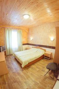 アブザコヴォにあるHotel Smileの木製の天井が特徴のベッドルーム1室(大型ベッド1台付)