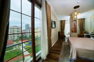 イスタンブールにあるVilla Vanilla Hotel & SPA Istanbul Asiaのベッドと大きな窓が備わるホテルルームです。