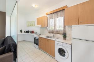 a kitchen with a washer and dryer in a room at Savvas Apartment in Afantou +1 photo