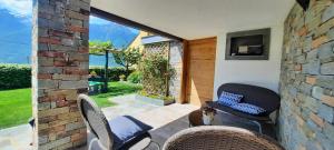 a patio with two chairs and a tv on a wall at B&B Monastero in Dubino