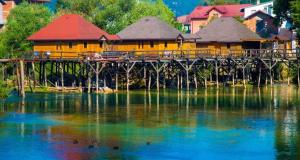 a building on a bridge over a body of water at Ferienwohnung Sabina in Bosanska Krupa