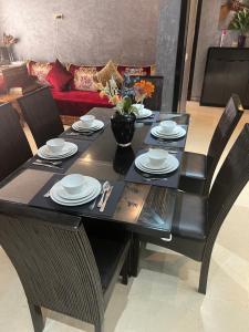 a black dining room table with chairs and a couch at Luxury apartments 3 in Casablanca
