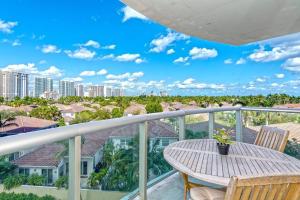 balcón con mesa, sillas y vistas a la ciudad en SPECIAL Beautiful Modern Beach Condo, en Miami Beach