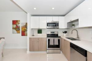 uma cozinha branca com um fogão e um micro-ondas em SPECIAL Beautiful Modern Beach Condo em Miami Beach