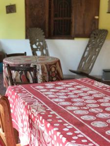 une table avec un tissu de table rouge et blanc dans l'établissement Karamba Lodge, à Kafountine