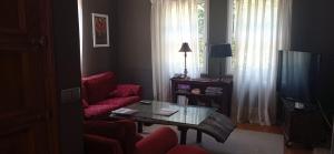 een woonkamer met een rode bank en een tafel bij CABANAS 1ª LINEA PLAYA in Cabañas