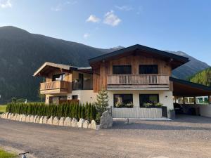 a large house with a mountain in the background at Alp Apart Niederthai in Umhausen