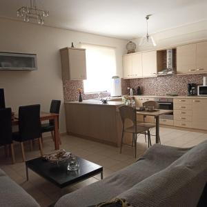 a kitchen and living room with a couch and a table at Nàra house in Áyios Spirídhon