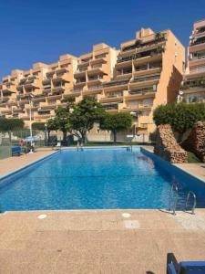 einem Pool vor einem großen Apartmenthaus in der Unterkunft Apartamento en primera línea de playa, frente al puerto de Aguadulce in Aguadulce