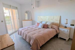 ein Schlafzimmer mit einem großen Bett mit Kissen darauf in der Unterkunft Apartamento en primera línea de playa, frente al puerto de Aguadulce in Aguadulce