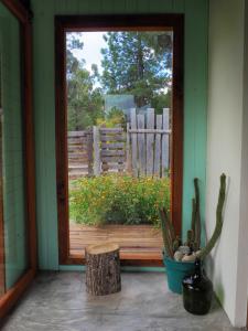 una puerta a un porche con una planta y una valla en Casa Lali en Lago Puelo