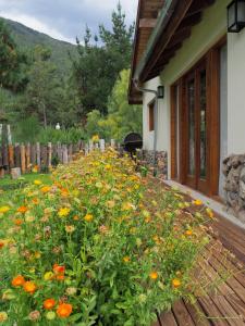 un campo de flores junto a una casa en Casa Lali en Lago Puelo