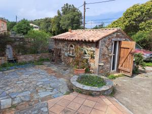 a small stone building with a door and a patio at Villa authentique à Patrimonio in Patrimonio +2 photos