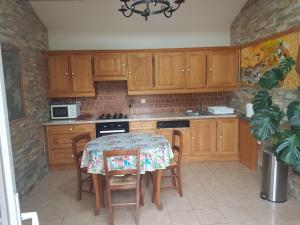 a kitchen with wooden cabinets and a table with chairs at Villa authentique à Patrimonio in Patrimonio