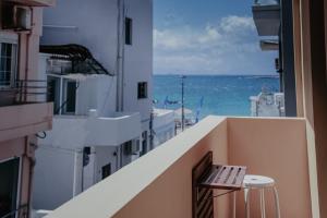 a bench sitting on a balcony looking out at the ocean at Tellus City in Chania Town