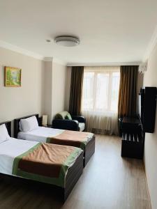 Habitación de hotel con 2 camas y sofá en Hotel Brighton, en Batumi