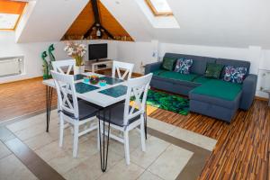 a living room with a table and chairs and a couch at Trend Apartments Old Market Rynek Rzeszów 84m2! in Rzeszów