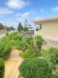 a garden with trees and bushes next to a house at Aurora Sol in Luz