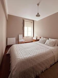 a bedroom with a large white bed with a window at Apartment Vedória in Viana do Castelo