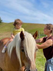 a woman and a child sitting on top of a horse at Tiny House i storslået natur in Frederikshavn