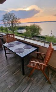 un tavolo e due sedie su una terrazza con vista sull'acqua di ‘Good Feelings’ a Siófok
