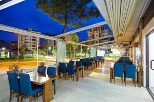 イスタンブールにあるVilla Vanilla Hotel & SPA Istanbul Asiaの青い椅子とテーブル、窓のあるレストラン