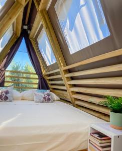 a bed in a tiny house with a window at A-luxury Glamping by La Mignola in Fasano