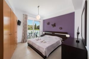 アファンドウにあるIliana Apartmentの紫の壁のベッドルーム(ベッド1台、テーブル付)