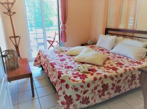 1 dormitorio con 1 cama con manta roja y blanca en Vaggelis Apartments, en Rodas
