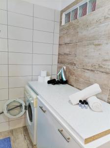 a laundry room with a washer and a washing machine at Vaggelis Apartments in Roda