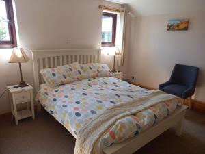 een slaapkamer met een bed en een blauwe stoel bij Castle View Apartment in Dunvegan