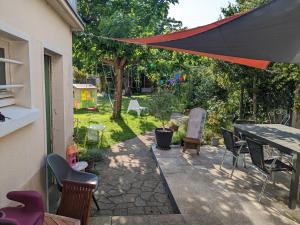 a patio with a table and chairs and a tent at Chez Agathe et Mathieu in Le Mans