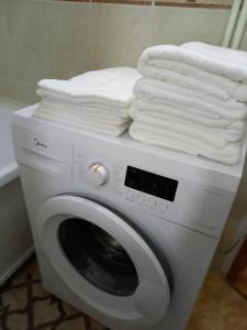 pralka z ręcznikami na górze w obiekcie ОРАНЖЕВЫЙ МИР w mieście Aktobe