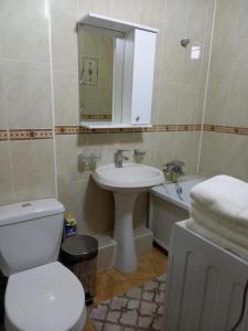 a bathroom with a toilet and a sink and a tub at ОРАНЖЕВЫЙ МИР in Aktobe