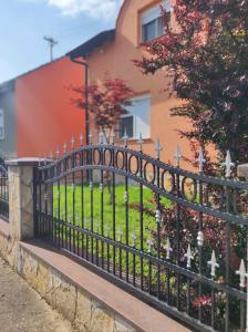une clôture en fer forgé noir devant une maison dans l'établissement Kuća za najam Villa Monika, à Osijek