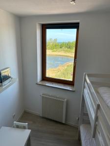 una camera da letto con finestra affacciata sul fiume di Wasserblick, in 3 Min am Strand a Heiligenhafen Altre 75 foto