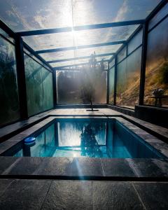 een zwembad in een huis met ramen bij Wolf Totem Industrial Chic Studio in Pisac