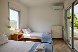 ネオス・マルマラスにあるSithonian Villaのベッド2台と窓が備わる小さな客室です。