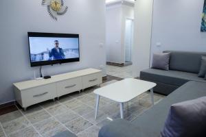 a living room with a flat screen tv on a wall at Fishta Apartments Q5 33 in Velipojë
