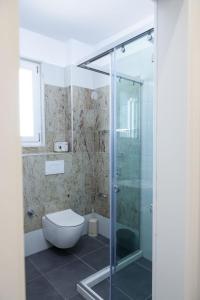 a bathroom with a toilet and a glass shower at Fishta Apartments Q5 33 in Velipojë