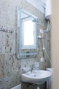 y baño con lavabo y espejo. en Fishta Apartments Q5 33 en Velipojë