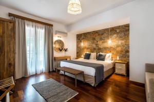 a bedroom with a bed and a stone wall at Leyla Luxury Villa in Pláka