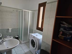 a bathroom with a washing machine and a sink at Casa di Ale in Siniscola +7 photos