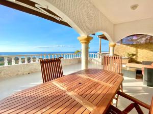 einen Holztisch und Stühle auf einem Balkon mit Meerblick in der Unterkunft Inviting 2-Bed Apartment in Cofresi in Las Flores
