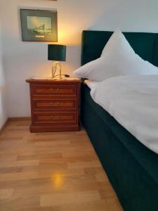 a bedroom with a bed and a night stand with a lamp at Gästehaus Föhr in Wintrich